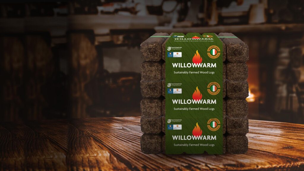 Image of a pack of WIllowWarm Briquettes with a burning fire in the background