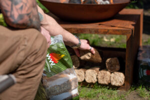 Topping up the fire with a WillowWarm briquette WillowWarm carbon-neutral briquettes burn perfect in outdoor stoves and fire pits and can be used all year round