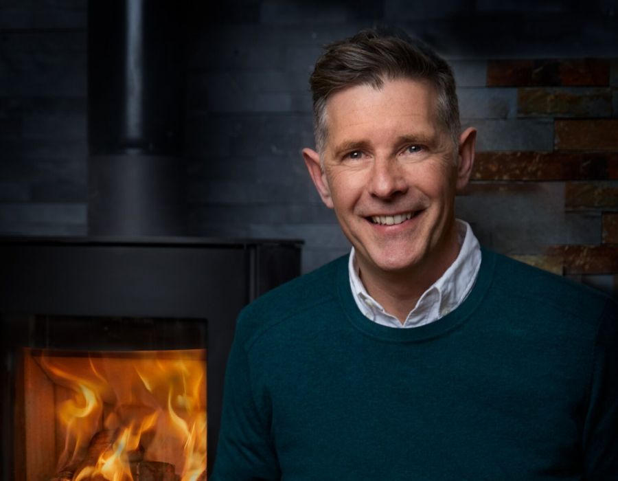 Dermot Bannon smiling with a burning stove behind him to promote the Home Consultation competition