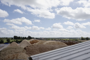 Piles of wood chips stacked at the WillowWarm manufacturing plant